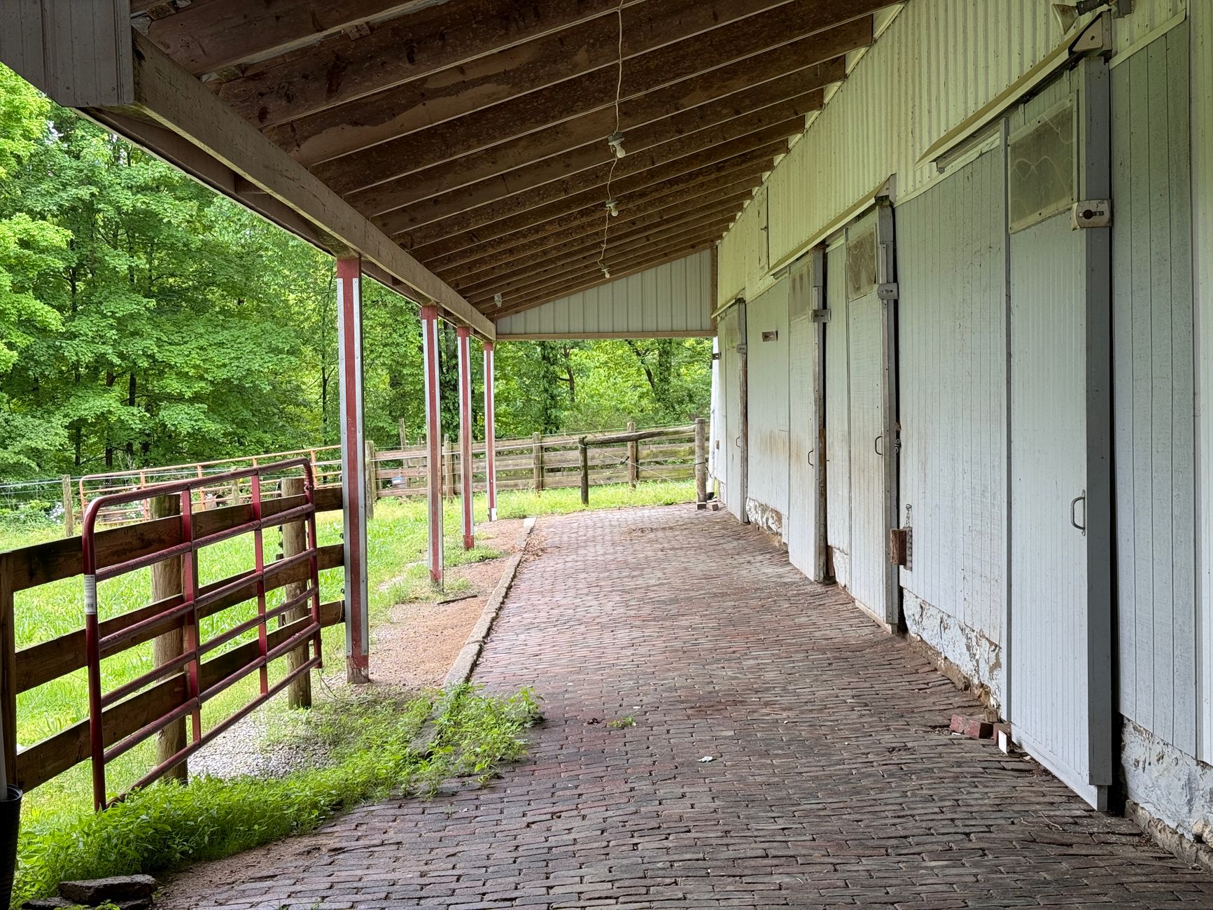 A barn aisle with brick flooring